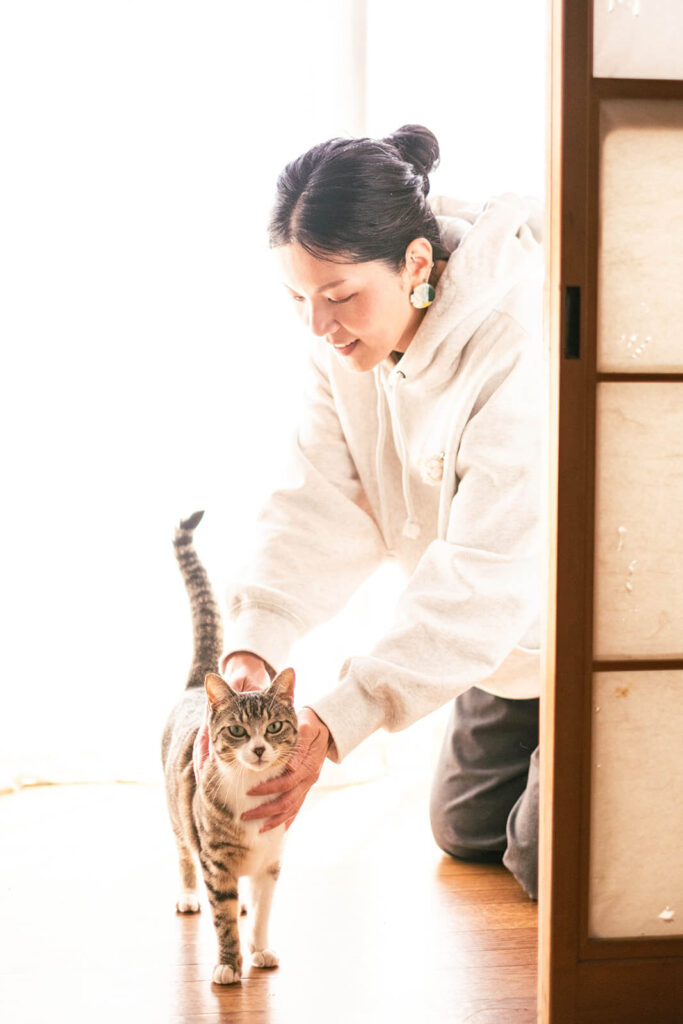 縁側で飼い主さんに撫でられているキジ白猫